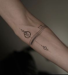 a person's arm with a clock and compass tattoo on it, in black ink