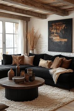 a living room with black couches and pillows