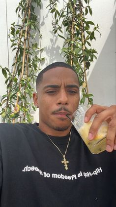 a man is drinking from a bottle with a straw in his mouth while sitting down