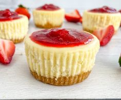 several mini cheesecakes with strawberries on the top and one strawberry in the middle