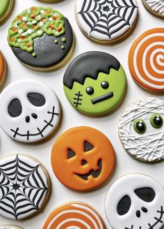 halloween decorated cookies are arranged on a white surface