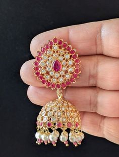 Transform your look and make a stunning statement with these Beautiful Indian Ruby Jhumka Earrings. Featuring Meenakari and Pearl drop accents, these Wedding Jhumkas are perfect for a traditional or contemporary Indian celebration. Beautiful Indian Ruby Jhumka Earrings/ Emerald Meenakari Earrings/ Jhumka Earrings with Pearl drop/ Wedding Jhumkas/ PRODUCT VARIATIONS - We strive to present each product with utmost accuracy and detail. However, due to the photography process, the item size may seem Temple Jewelry Meenakari Drop Jhumkas, Indian Celebration, Earrings Jhumka, Meenakari Earrings, Earrings Emerald, Jhumka Earrings, Pearl Drop, Jewelry Earrings Dangle, Dangle Drop Earrings