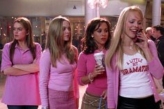 the mean girls in pink are talking on their cell phones and drinking coffee while standing next to each other