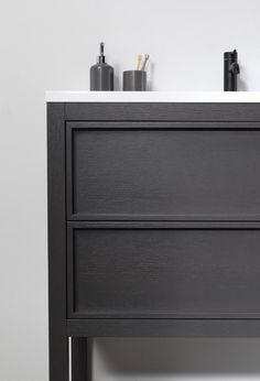 a bathroom vanity with two drawers and soap dispensers