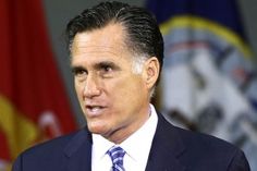 a man wearing a suit and tie standing in front of flags