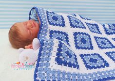 a baby is sleeping under a blue and white crocheted blanket with a teddy bear