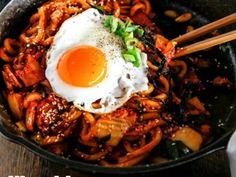 an egg is on top of noodles in a skillet