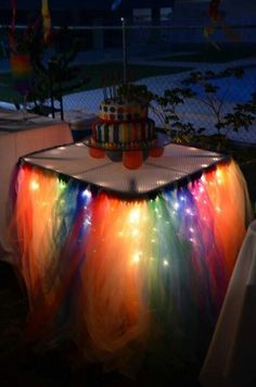 a table topped with a cake covered in colorful lights