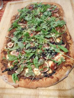 a pizza sitting on top of a wooden cutting board covered in veggie toppings