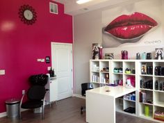 a salon with pink walls and white shelving