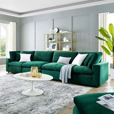 a living room filled with green couches and white rugs on top of a hard wood floor