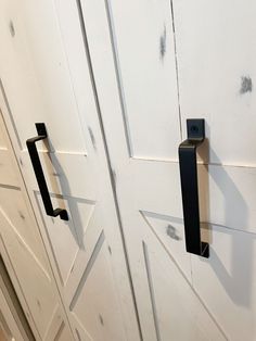 two black handles are on the white doors