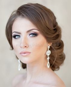 a beautiful woman with blue eyes wearing earrings