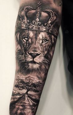 a lion with a crown on his head is shown in this black and grey tattoo