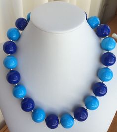 This chunky blue necklace is 18 1/2 inches in length with a 2 inch extender chain and a lobster claw clasp. Filigree bead caps on each end add an antique look to the light blue and royal blue 20 mm acrylic beads. Silver plated spacers separate each acrylic bead.  ATTENTION: Decorative use only. Contains small pieces. Not a toy. Do not put in mouth. Blue Beaded Necklaces With Lobster Clasp For Jewelry Making, Blue Beaded Jewelry With Lobster Clasp, Blue Round Bead Necklace With Lobster Clasp, Blue Round Single Strand Beaded Necklaces, Blue Beaded Necklaces For Jewelry Making, Blue Round Single Strand Beaded Necklace, Blue Necklace With Round Beads And Lobster Clasp, Blue Beaded Necklaces With Lobster Clasp And Round Beads, Blue Beaded Necklaces With Lobster Clasp