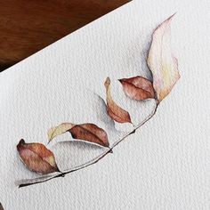 watercolor painting of three leaves on white paper with wood table in the back ground