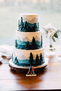 a three tiered cake sitting on top of a wooden table