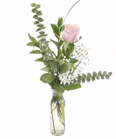 a vase filled with flowers and greenery on top of a table