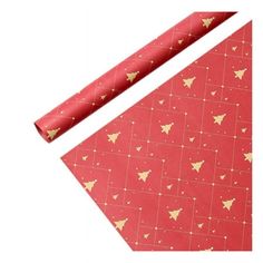 red wrapping paper with gold triangles and stars on it next to a roll of foil