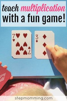 two hands holding playing cards with the words teach multiplication with a fun game