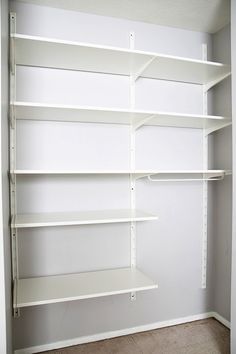 an empty closet with white shelving in the corner and carpeting on the floor