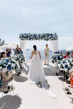 a bride and groom walking down the aisle at their wedding ceremony with an ocean view