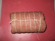 a piece of bread wrapped in twine on a red surface