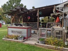 an outdoor kitchen with potted plants on the deck and in the background is a shed