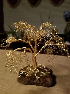 a gold tree sculpture sitting on top of a table