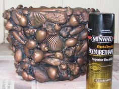 a close up of a spray paint near a potted plant and a canister