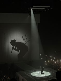 a man standing on top of a stage in front of a crowd