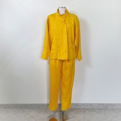 Vintage 90s yellow trouser suit. The suit consists of trousers and jacket. The trousers have a high waist and two pockets. The jacket has chest pockets and an oversized fit. Fabric:  54% viscose 46% linen  Size: 40 JACKET SIZE Shoulders: raglan sleeves Chest: 66cm / 25.9" Length: 64cm / 25.1" Sleeve Length: 70cm/27.5" PANTS SIZE Waist: 36cm/14.1" Height: 52cm / 20.4" (flat) Length: 104cm / 40.9" The suit has a small stain (photo), but overall it is in excellent condition Yellow Spring Pantsuit For Workwear, Yellow Pantsuit For Spring Workwear, Spring Yellow Pantsuit For Workwear, Yellow Spring Pantsuit For Work, Spring Yellow Suits For Workwear, Yellow Suits For Spring Workwear, Yellow Long Sleeve Suits For Spring, Spring Yellow Suits For Work, Yellow Long Sleeve Pantsuit For Spring