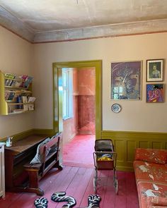 a living room filled with furniture and pictures on the wall