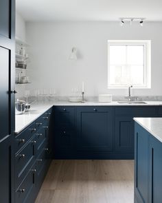 a kitchen with blue cabinets and white counter tops