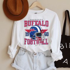 Perfect sweatshirt for any Buffalo football fans this season! Ideal for any situation, a unisex heavy blend crewneck sweatshirt is pure comfort. These garments are made from polyester and cotton. This combination helps designs come out looking fresh and beautiful. The collar is ribbed knit, so it retains its shape even after washing. There are no itchy side seams on these sweaters.  .: 50% cotton, 50% polyester .: Medium-heavy fabric (8.0 oz/yd² (271.25 g/m .: Loose fit .: Sewn-in label .: Runs true to size CARE INSTRUCTIONS: -Please wash all clothing items INSIDE OUT to preserve the design. -Please wash all clothing items on cold, and dry on Medium- low heat. -DO NOT IRON. -DO NOT TIE DYE. **Please check our color and size charts before you place your order. If you have any questions plea White Pre-shrunk Sweatshirt For Fan Merchandise, Football Season Fan Merchandise Graphic Print Sweatshirt, White Crew Neck Sweatshirt With Team Logo, White Sweatshirt For Sports Season Fan Gear, White Team Name Sweatshirt For Fans, White Crew Neck Sports Fan Sweatshirt, White Screen Print Sweatshirt For Fan Gear, White Crew Neck Sweatshirt For Sports Fans, White Fan Apparel Sweatshirt