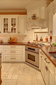 a kitchen with white cabinets and marble counter tops, along with an oven and dishwasher