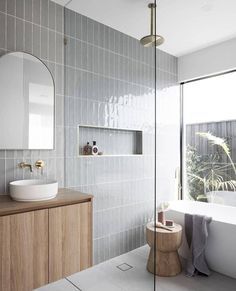 a bathroom with a sink, mirror and bathtub next to a large glass window