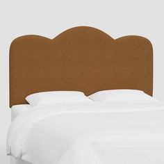 an upholstered headboard on a bed with white sheets