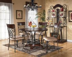 a dining room table with four chairs and fruit on the plate in front of it