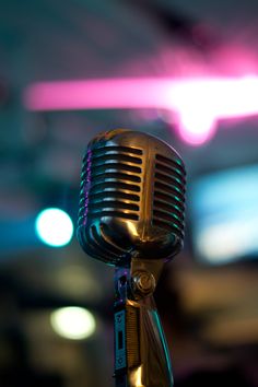 an old fashioned microphone with blurry lights in the background