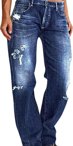 a man wearing blue jeans with holes on the side and his hands in his pockets