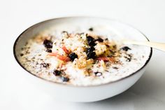 a bowl of oatmeal with raisins and blackberries in it