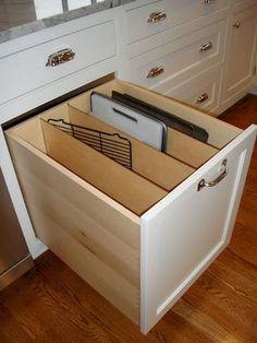 an open drawer in the middle of a kitchen