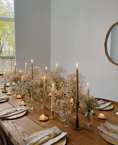 a long table is set with candles and place settings