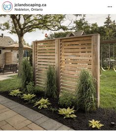 a wooden fence next to a lush green yard