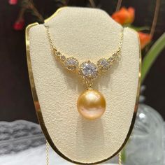 A stunning natural yellow pearl, carefully selected for its rich hue and radiant luster. Decorated this central gem is a halo of meticulously set zircon stones. It creates a luxurious and captivating effect, making this necklace a perfect statement piece for any high-end occasion like a gala, a sophisticated dinner, or an important celebration, this necklace promises to elevate your ensemble with its unmatched grandeur. Pearl Type: Freshwater Edison Pearls Pearl Quality: AAA [Shape]: Perfect Rou Gold Pearl Necklace With Gemstones For Wedding, Yellow Pearl Necklace As Gift, Elegant Round Gemstone Bridal Necklace, Formal Bridal Necklace With Pearl Pendant, Gold Pearl Necklace With Cubic Zirconia, Yellow Gold Cubic Zirconia Necklace With Pearl Pendant, Yellow Pearl Necklace For Gift, Yellow Pearl Necklace Gift, High Luster Diamond Necklace For Anniversary