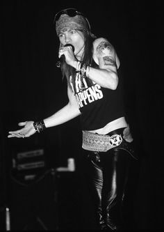 a woman standing on top of a stage with her arms out to the side while holding a microphone