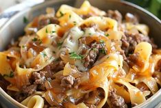 a bowl filled with pasta and meat covered in cheese