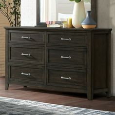 a dresser with a mirror and vase on top