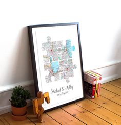 a framed map is sitting on the floor next to a potted plant and books